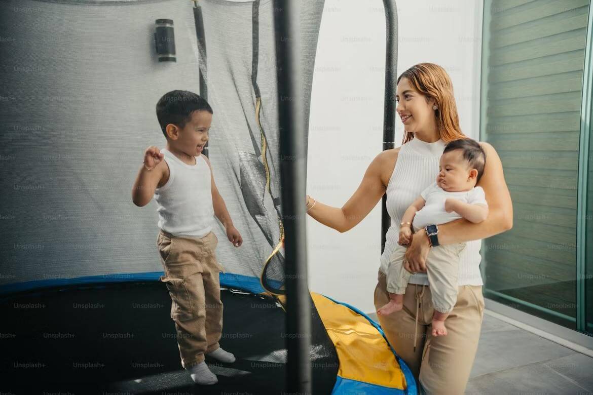 A caregiver consoling a toddler at a gym with childcare